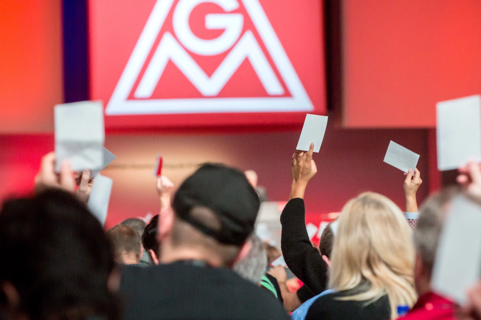 Menschen von hinten, die Abstimmungskarten nach oben halten.